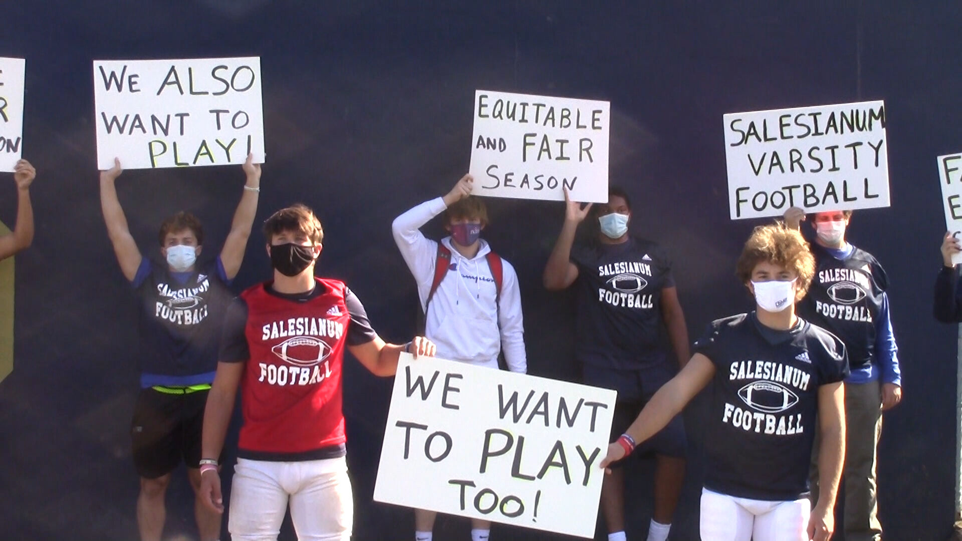 Salesianum football players hold up signs during a protest before practice on Wednesday, October 14, 2020